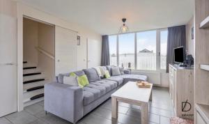 a living room with a couch and a table at Duinengolf in Middelkerke