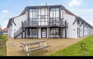 a large white building with a bench in front of it at Duinengolf in Middelkerke