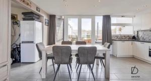 a kitchen with a table and chairs in a kitchen at Duinengolf in Middelkerke +12 photos