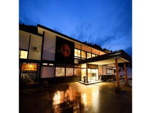 ein großes Gebäude mit vielen Fenstern in der Nacht in der Unterkunft Oyasukyo Onsen Ryokan Tarobee - Vacation STAY 56805v in Yuzawa