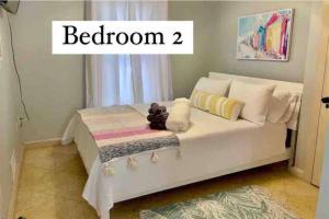 ein weißes Bett in einem Zimmer mit der Aufschrift Schlafzimmer zwei in der Unterkunft Be A Nomad - Oceanviews Bottom and Steps to the Beach in Jacksonville Beach