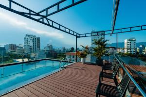 a deck with two chairs and a swimming pool on a building at Dérive Boutique Villa & Apartment Da Nang in Danang