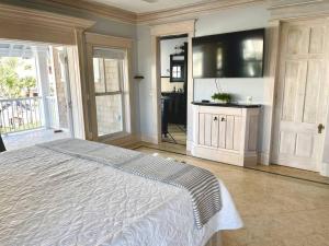 ein Schlafzimmer mit einem großen Bett und einem großen TV in der Unterkunft Be A Nomad - Stunning Old World Home Top Oceanviews in Jacksonville Beach