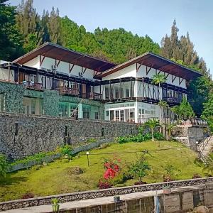 a large house on top of a stone wall at Tiara Bunga Hotel & Villa in Balige