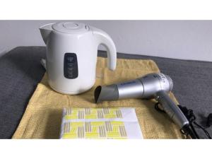 una macchina per il caffè appoggiata accanto a una tazza su un tavolo di Biz Hotel Kiyura - Vacation STAY 93177v a Yura