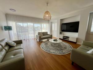 Jo Sea - New build, Luxury in Vincentia with Ocean Views的电视和/或娱乐中心