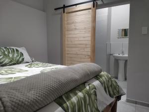 a bedroom with a bed and a bathroom with a sink at Amapondo in Port St. Johns