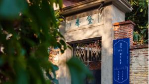 厦门厦门市和院黛峰人文民宿的一栋建筑的窗前有蓝色标志