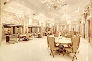 a large dining room with a table and chandeliers at Marks Hotel & Banquet in Noida