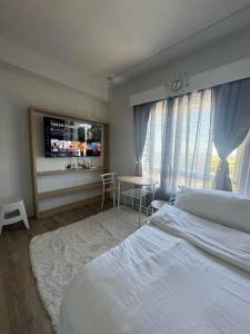 a bedroom with a bed and a tv and a table at Xavi's Condo Rental in Bacolod