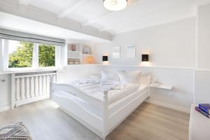 a white bedroom with a bed and a window at Buhne 44 in List