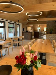 a room with tables and chairs and a vase of flowers at Lešná Penzion in Zlín