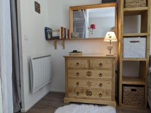 - une chambre avec une commode avec un miroir et une lampe dans l'établissement studio terrasse de charme près des pistes, à Bernex 17 autres photos