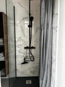 a shower with white marble walls and a shower curtain at La maison des Graviers in Nogent-sur-Seine +22 photos