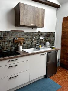 a kitchen with white cabinets and a sink at La maison des Graviers in Nogent-sur-Seine