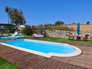 a swimming pool on a wooden deck next to a yard at Angel's House in Alcobaça