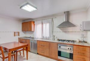 a kitchen with a table and a stove top oven at Quic in Playa de Muro