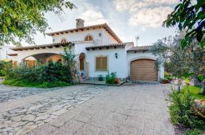 a white house with a garage and a driveway at Quic in Playa de Muro