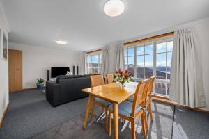 サンディ・ベイにあるLuxury Sandy Bay Living River Views Free Parkingのテーブルと椅子とソファのあるリビングルーム +9枚の写真