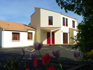 a white building with red doors and purple flowers at Le Logis De Saint-Martin in Haute-Goulaine +7 photos