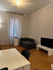 Una sala de estar con un sofá y un televisor de pantalla plana. en Cerri apartment, en Roma