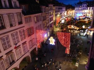 70 m² Strasbourg Appart city center في ستراسبورغ: اطلالة جوية على مدينة بالليل مع انارة العيد