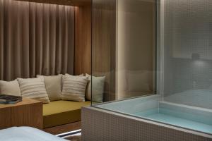 a bathroom with a tub and a bed and a shower at HotelCO Kuramae ホテル コ 蔵前 in Tokyo