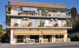 a large building with a store front with a balcony at Albergo Casa Lupi in Guidonia
