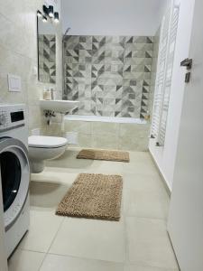 a bathroom with a sink and a washing machine at Milan Luxury Apartaments VI-Maurer Residence in Târgu-Mureş