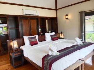 a bedroom with a large bed with two stuffed animals on it at Koh Mook Sivalai Beach Resort in Ko Mook