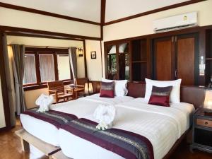 a bedroom with two beds with white towels on them at Koh Mook Sivalai Beach Resort in Ko Mook