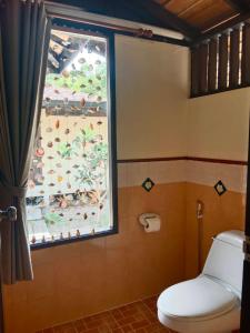 a bathroom with a window and a white toilet at Koh Mook Sivalai Beach Resort in Ko Mook