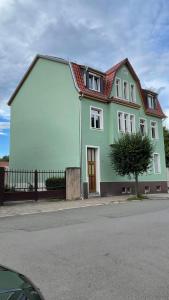 a green and white house on the side of a street at NEU! OASIS - FeWo am Harz, hochwertig Kernsaniert, 83 qm, EG in Nordhausen