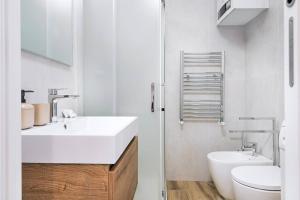 ミラノにあるEasylife - Milano - Col di Lana 1 - Navigliの洗面台とトイレを備えた白いバスルーム +19枚の写真