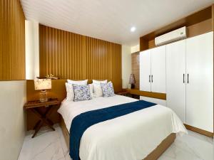 a bedroom with a large bed with a blue blanket at Dahlia Homestay Tay Ho in Hanoi