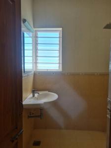 a bathroom with a white sink and a window at Zephyr Home near Pearl Beach in Cheyūr