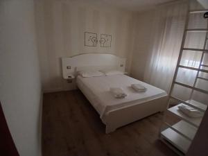 Un pequeño dormitorio con una cama blanca en una habitación en The Magic Place, en Quartu SantʼElena