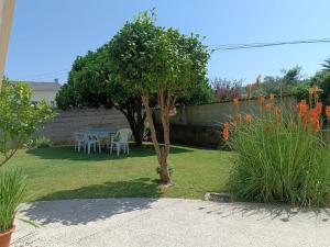 a garden with a table and chairs and a tree at Casa en San Pantaleón in Paderne