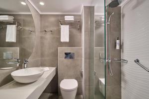 a bathroom with a toilet and a sink and a shower at Blue Sea Beach Resort in Faliraki