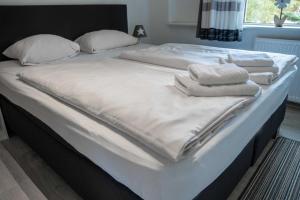 a large bed with white sheets and towels on it at Villa Nordhang - Apartment 5 in Winterberg
