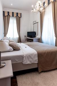 sypialnia z dużym łóżkiem i telewizorem w obiekcie Boutique Hotel Kaštel w mieście Motovun