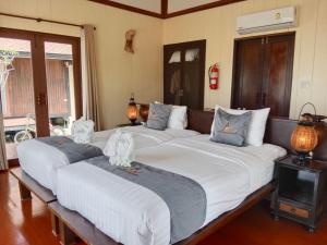 a group of four beds in a room at Koh Mook Sivalai Beach Resort in Ko Mook