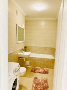 a bathroom with a toilet and a sink and a tub at Milan Luxury Apartaments III-Maurer Residence in Târgu-Mureş
