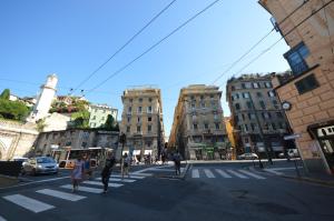 a group of people crossing a busy city street at Mami Affittacamere in Genova