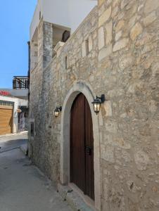 a stone building with a wooden door and a street at Casa Leone, whole house with private pool! in Atsipopoulo +16 photos