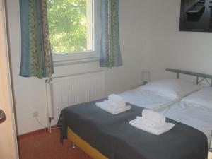 a bedroom with a bed with two folded towels on it at Ferienhaus Bolliger Apartment 2 in Kalkhorst +2 photos