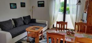 Bungalow Rose في لودين: غرفة معيشة بها أريكة وطاولة