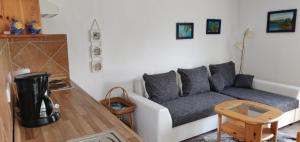 Bungalow Rose في لودين: غرفة معيشة بها أريكة وطاولة