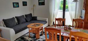 Bungalow Rose في لودين: غرفة معيشة مع أريكة وطاولة وكراسي +4 صور