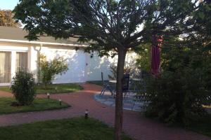 un albero nel mezzo di una passerella di mattoni di Ferienwohnung Kienast 1 a Pudagla Altre 3 foto